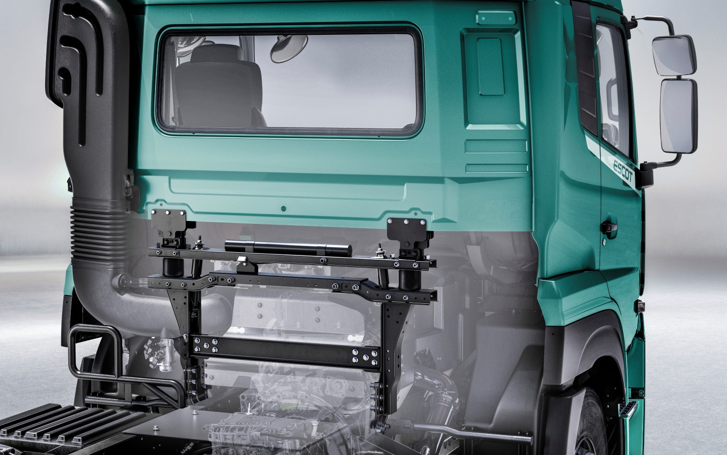 Green truck cab with partially transparent lower section showing internal structure.
