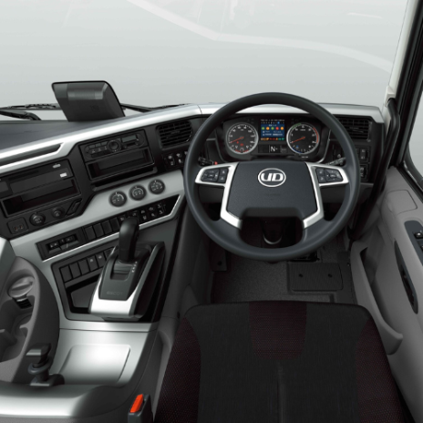Modern truck dashboard with digital controls, steering wheel, and gear shift.