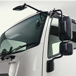 Close-up of a white truck cab showing large side mirrors and windshield.