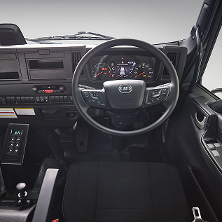 Truck dashboard with steering wheel, digital display, and control panels in black interior.