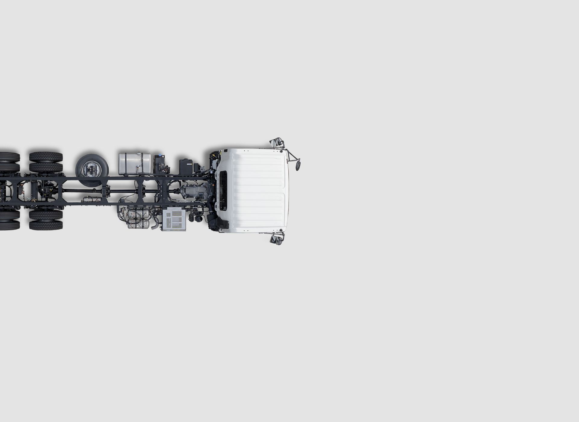 White truck cab and chassis viewed from above on a plain light grey background.