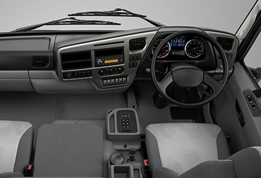 Truck interior dashboard with steering wheel, instrument panel and two front seats.